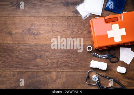 Trousse de premiers soins avec de l'équipement médical sur fond de bois Banque D'Images