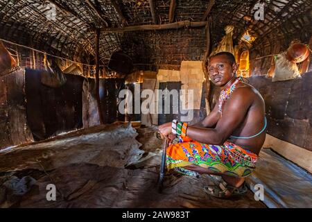 Samburu homme assis à l'intérieur de la maison de village, à Samburu, au Kenya Banque D'Images