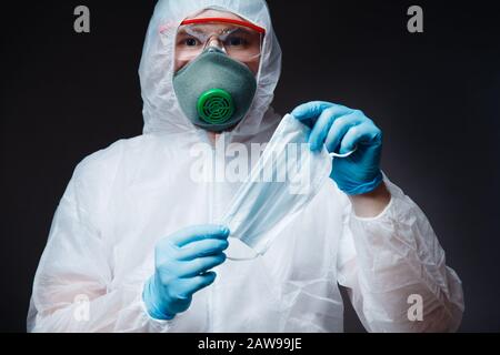 Medic homme en blanc hazmat de protection tenue gaze bandage masque pour les maladies respiratoires pneumonie épidémie de coronavirus. Banque D'Images