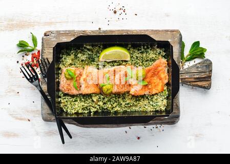 Filet de poisson cuit à la sauce tomate avec sarrasin vert et épinards. Livraison du plat du restaurant. Vue de dessus. Espace libre pour votre texte. Banque D'Images