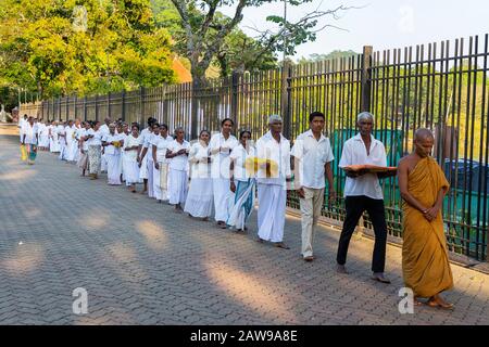 Procession de la population locale transportant des offrandes au Temple de la dent relique, à Kandy, Sri Lanka Banque D'Images