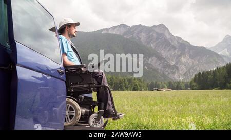 lève-personnes véhicule spécialisé pour personnes handicapées. Fauteuil roulant vide sur une rampe avec nature et montagnes à l'arrière Banque D'Images