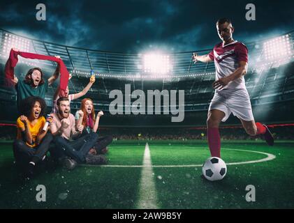 Fans de football au milieu de l'action pendant une partie de nuit au stade Banque D'Images