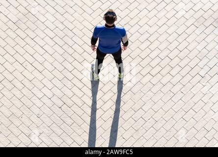 vue de dessus d'un jeune homme qui s'efforce d'écouter de la musique. concept de vie saine. Banque D'Images