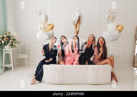 Souriant belles femmes en vêtements de nuit passer du temps ensemble pendant la fête à la maison. Concept de fête d'anniversaire Banque D'Images