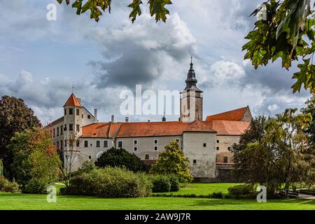 Telc / République tchèque - 27 septembre 2019: Vue sur un château d'état et une tour de l'église de James le Grand d'un parc public avec des arbres verts. Banque D'Images