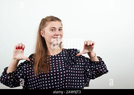 fille dans une robe noire avec des cercles blancs humeur négative posted pouces vers le bas Banque D'Images