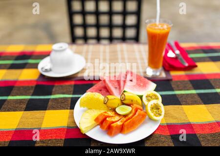 Assiette de fruits. Fruits frais et juteux dans une assiette sur un fond de montagnes. Banque D'Images