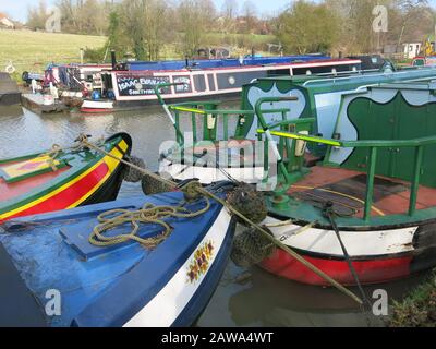 Des bateaux de étroite peints dans des couleurs vives amarrés au chemin d'attelage sur les rives du canal Grand Union, près de la marina de Braunston, dans le Northamptonshire Banque D'Images