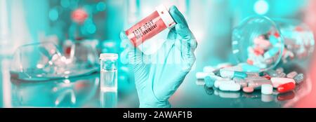Contexte pharmaceutique médical du coronavirus panoramique. La main dans le gant contient des pilules de médicament, inhibiteur du roman 2019-nCoV coronavirus infection testée sur pa Banque D'Images