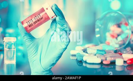 Antécédents médicaux de coronavirus en pharmaceutique. La main dans le gant contient des pilules de médicament, inhibiteur de l'infection de coronavirus 2019-nCoV cliniquement testée sur le patient Banque D'Images