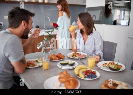 les jeunes adultes s'amusent tout en prenant le petit déjeuner. moderne, décontracté, style de vie Banque D'Images