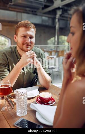 Un couple heureux s'asseoir dans le café s'amuser et s'amuser à parler Banque D'Images