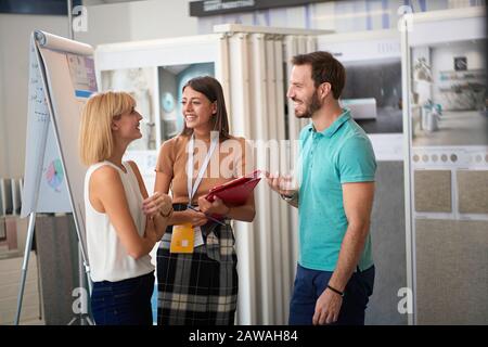 un jeune couple qui parle avec le directeur des ventes a un décor intérieur abut au magasin de carreaux de céramique. choix, achat, vente concept. personnel sympathique Banque D'Images