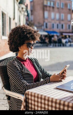 Jeune femme d'affaires qui vérifie un téléphone portable intelligent Banque D'Images