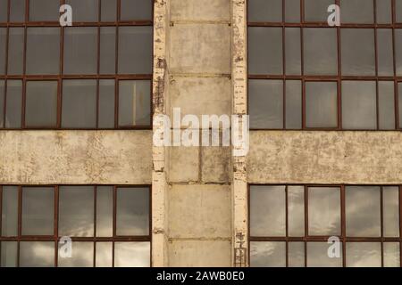 Grandes fenêtres de l'usine sur le fond de la paroi de ciment Banque D'Images