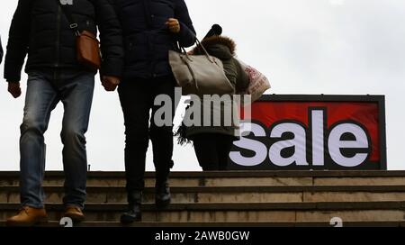 Bucarest, Roumanie - 06 janvier 2020: Les gens passent par un panneau sur lequel il est écrit vente est vu dans une rue à Bucarest. Banque D'Images