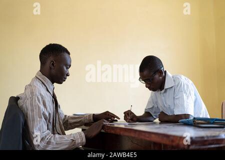 Les collaborateurs d'affaires afro-américains travaillent ensemble à la signature d'un emploi d'affectation Banque D'Images