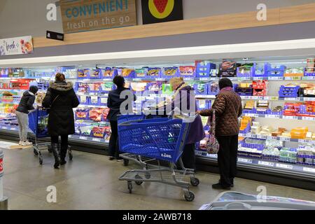 Les gens font du shopping dans l'allée de fromage dans un magasin de Lidl à New York, NY Banque D'Images