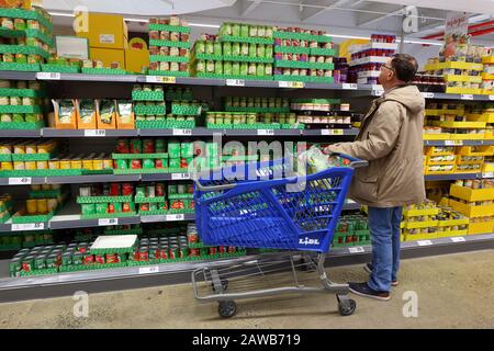 Une personne qui fait du shopping dans une allée de marchandises en conserve dans un magasin de Lidl à New York, NY Banque D'Images