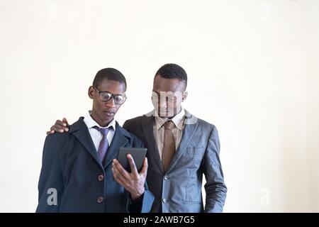 Deux Jeunes Hommes D'Affaires Noirs Travaillant Sur Tablette Dans Le Bureau Blanc Banque D'Images
