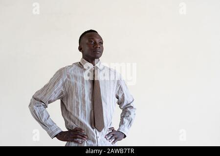 Fier homme africain Posant pour sa compagnie isolée sur blanc Banque D'Images