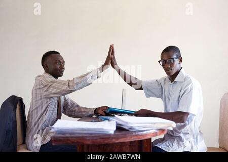 Couple d'Hommes d'Affaires autochtones noirs d'Afrique High Fiving l'un l'autre dans le bureau pour le nouvel emploi ou projet Banque D'Images