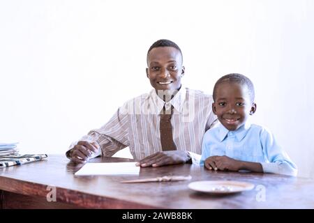 Candié du père et du fils de la famille africaine le premier jour de l'école dans un bureau scolaire Banque D'Images