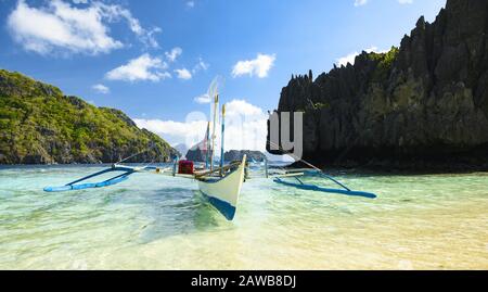 Vue imprenable sur une Bangka flottant sur une mer turquoise et cristalline. Un Bangka est un canot à double sortie originaire des Philippines. Banque D'Images