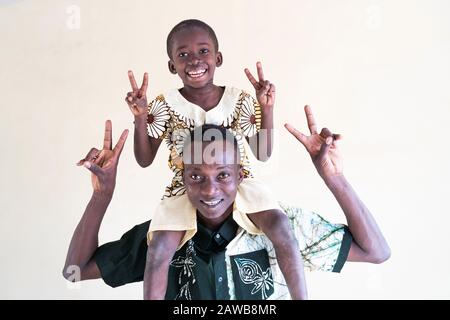 Joyeux père et fils noirs africains s'amuser à l'intérieur ensemble montrant le symbole de la paix devant un arrière-plan isolé Banque D'Images