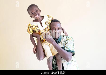 Drôle ensemble jouer un père noir africain avec son fils sur ses épaules souriant et riant avec un jeu de gai Banque D'Images