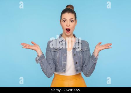 OH mon dieu, wow! Portrait d'une jolie jolie jolie femme habillée avec un pain de cheveux debout avec des mains levées et ouvert la bouche avec étonnement, choqué par des Banque D'Images