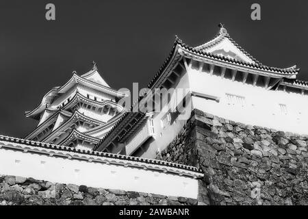 Hauts de tours historiques dans le château japonais de shogun près de la ville d'Osaka au-dessus des murs en pierre, à l'impression noir-blanc contraste. Banque D'Images