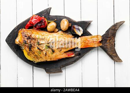 Perchaude alimentaire rouge cuite aux champignons et au poivre rouge.poisson cuit sur la planche de cuisine Banque D'Images