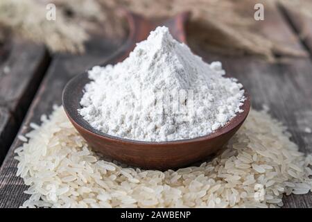 Farine de riz dans une cuillère sur une pile de riz blanc sur de vieux planches. Riz au jasmin pour la cuisson. Banque D'Images