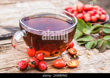 Tasse de thé au rosehip avec des baies fraîches sur une table en bois. Phytothérapie. Banque D'Images