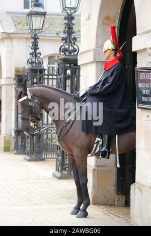 Household Cavalry dans leurs longs manteaux traditionnels uniforme bleu à Whitehall, Londres, UK Banque D'Images