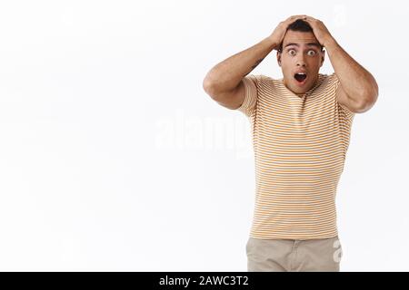 Anxieux, inquiet jeune homme joueur qui regarde troublé et bouleversé, assèchent l'appareil-photo étoilé, ne sais pas quoi faire, face à une énorme proble, ayant gros Banque D'Images