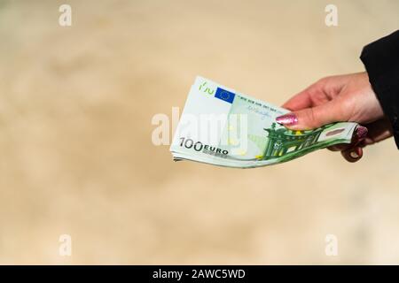 Femme main tenant et donnant de l'argent. Concept monétaire mondial, gros plan de 100 billets D'EUROS, photo de la monnaie européenne isolée. Main tenant de l'argent, EURO curr Banque D'Images