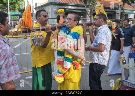 Pour le festival hindou de Thaipusam, un participant chinois ethnique porte un poteau attaché avec des pots de lait; Little India, Singapour Banque D'Images