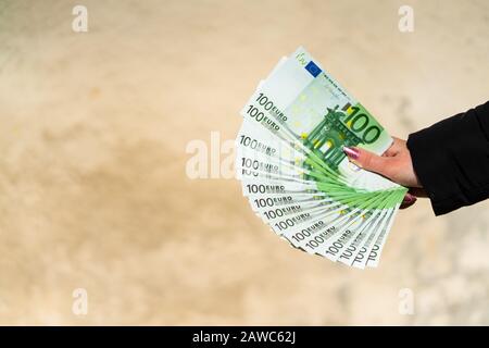 Femme main tenant et donnant de l'argent. Concept monétaire mondial, gros plan de 100 billets D'EUROS, photo de la monnaie européenne isolée. Main tenant de l'argent, EURO curr Banque D'Images