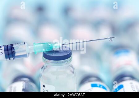 Seringue sur les flacons de médicaments sur fond bleu. Aiguille d'injection et médicaments pour le milieu médical. Concept de vaccination. Banque D'Images