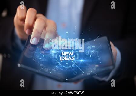 Businessman holding a smartphone pliable avec de nouvelles idées, inscription nouveau concept commercial
