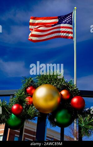 Un drapeau américain survolant les décorations de Noël sous un ciel bleu Banque D'Images