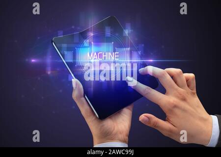 Businessman holding a smartphone pliable avec inscription de la machine, la nouvelle technologie concept Businessman holding a smartphone pliable avec inscription de la machine, la nouvelle technologie concept