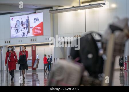 Deux agents de bord Cathy Pacific ont vu porter des masques chirurgicaux comme une mesure de protection contre le coronavirus mortel à l'aéroport international de Hong Kong.Des Centaines de vols entre les villes chinoises continentales et Hong Kong sont annulés comme la mesure de quarantaine obligatoire de 14 jours que les voyageurs devront rester à la maison ou à l'hôtel à mettre en quarantaine prend effet. Banque D'Images