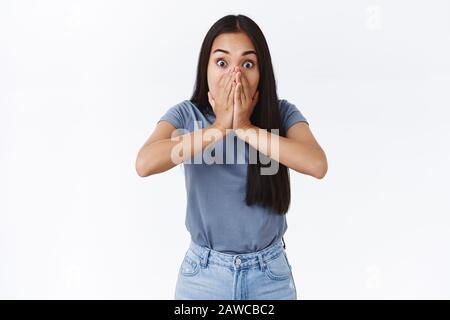 Choquée, sans voix, la jeune fille de brunette asiatique qui a surpassé son appareil photo, étonnée, époussante, ne tient pas sa bouche à hurler de secouer et d'étonner, témoin quelque chose Banque D'Images