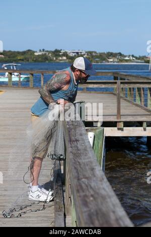 Un pêcheur tatoué se prépare à jeter son filet dans la poche Manatee au Sandsprit Park à Port Salerne, Floride, États-Unis. Banque D'Images