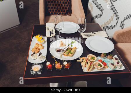 Différents canapés avec saumon fumé, tomates cerises au concombre et mozzarella servis sur une table Banque D'Images