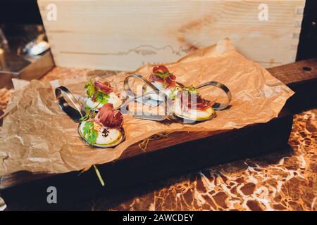 Différents canapés avec saumon fumé, tomates cerises au concombre et mozzarella servis sur une table Banque D'Images